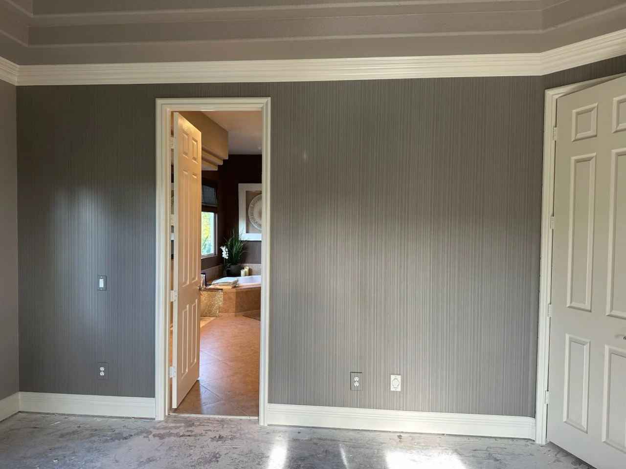 Wallpapered foyer with grasscloth feature wall by Wallpaper Installers Service